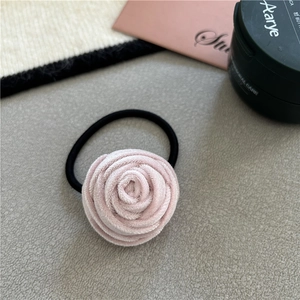 Detail of a pink velvet rose flower hair scrunchie with a black elastic hair tie band