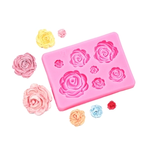 Detail of pink silicone mold with multi-size 3D rose cavities and colorful soap samples