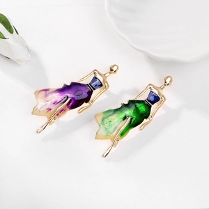 Detailed close-up of elegant dancing girl brooches with colorful enamel finish on gold metal