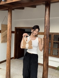 Detail of handcrafted woven bag with hollow diamond pattern in beige and brown