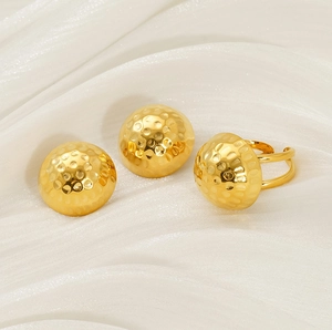 Detail view of 18K gold hammered round stud earrings and adjustable ring set on silk