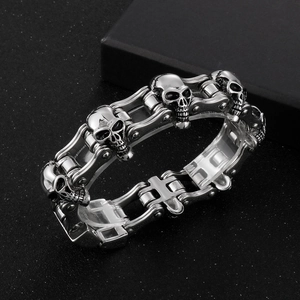 Detail of vintage silver skull charm on a stainless steel motorcycle chain bracelet