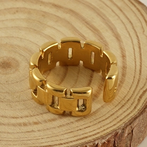 Modern 18k gold geometric chain-link stainless steel open ring on a natural wood stand