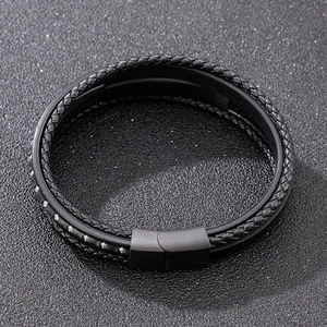 Detail of multi-layer black braided leather bracelet with a matte metal magnetic clasp