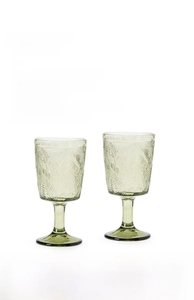 Detailed macro view of retro embossed green glass goblet with exquisite leaf patterns