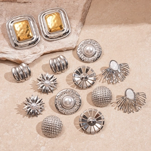 Set of vintage geometric gold and silver earrings with pearls on textured stone