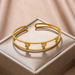 Detail of gold-plated stainless steel cuff featuring double-layered beads and snake motifs