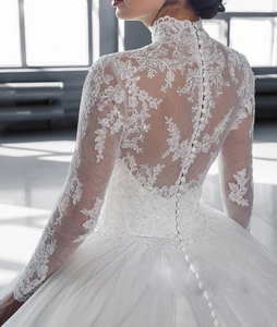 Détail du dos d'une robe de mariée avec broderie dentelle et boutons élégants