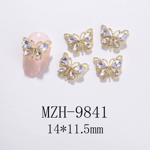 Macro shot of 3D gold hollow butterfly nail art charms with iridescent rhinestones