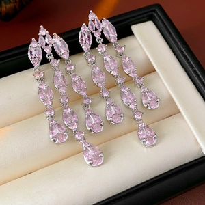 Macro detail of silver drop earrings with pink marquise and pear-cut zircons in box