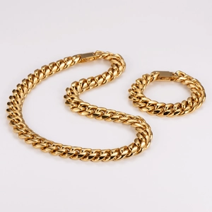 Vista macro del set collana e bracciale a maglia cubana dorata con finitura lucida