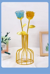Detail of blue and yellow crystal resin roses in a minimalist gold wire frame vase