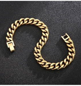 Detailed top view of gold Cuban link bracelet on a matte black textured background