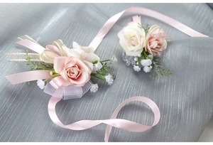 Dettaglio di corsage da polso per sposa con nastri di raso e rose artificiali