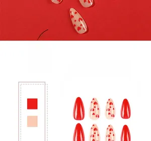 Detail of almond-shaped Valentine nails with red heart patterns and glossy finish