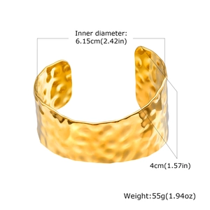 Detailed view of wide gold cuff bracelet with hammered texture and dimension markings