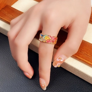 Chunky gold-plated ring with colorful enamel floral patterns and sparkling zircons on hand