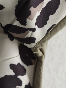 Detail of leopard print fabric with olive green lining and textured woven material