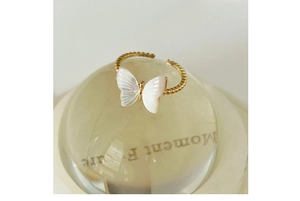 Close-up of golden pearl butterfly ring with unique beaded texture on adjustable band