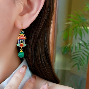 Detail of 18K gold-plated earring with blue enamel, red inlay and green bead on model