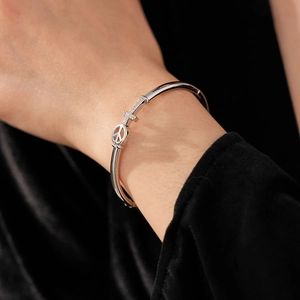Detailed view of silver arrow cross cuff bracelet with sparkling diamonds on wrist