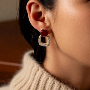 Vue macro des boucles d'oreilles vintage dorées avec pierres rouges et zircons