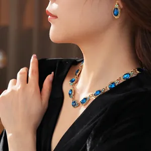 Parure de bijoux vintage dorée avec cristaux ovales bleu saphir et détails brillants
