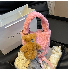 Détail du sac seau rose en polaire avec un joli pendentif ours marron et étiquette