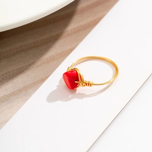 Macro shot of handmade gold wire-wrapped ring with irregular red gemstone detail