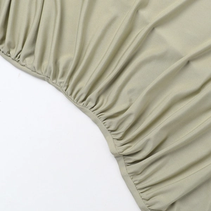 Detailaufnahme des olivgrünen Stoffes mit geraffter Textur und elastischem Falten-Design