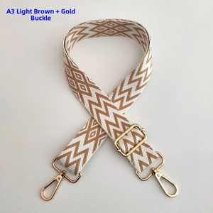 Detail of adjustable wide shoulder strap with light brown wave pattern and gold metal hooks