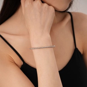 Close-up of a silver rope style twisted open cuff bracelet on a woman's wrist