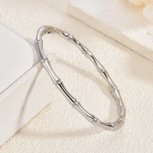 Detailansicht eines silbernen Bambus-Armbands auf einer weißen Premium-Geschenkbox