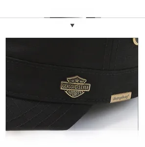 Detail of metal shield logo and classic-style sports engraving on black cotton army cap