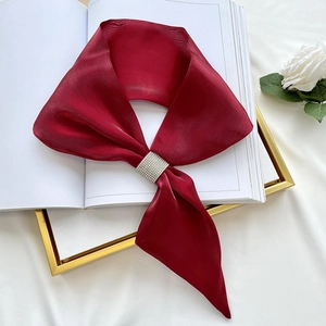 Detail of dark red silk neckerchief with a sparkling diamond-studded square slider buckle