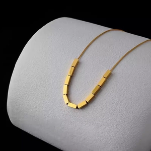 Minimalist gold square necklace with sleek snake chain on a premium display stand