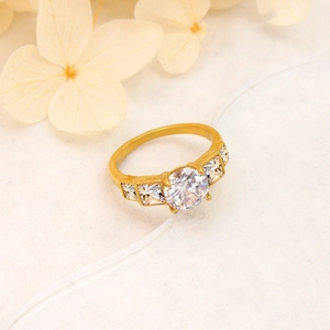 Macro shot of a gold-plated ring with a central round zircon and small side stones