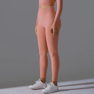 Detail of high-waist seamless leggings and thumbhole sleeves in apricot orange knit