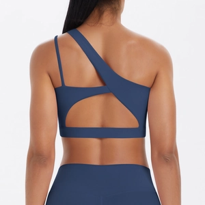 Detail of dark blue one-shoulder sports bra with criss-cross back and brushed texture