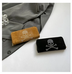 Detail of brown and black suede long wallets with rhinestone skull and gold zipper