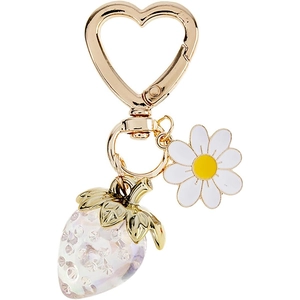 Detail of strawberry keychain with golden heart clasp, white daisy and iridescent charm