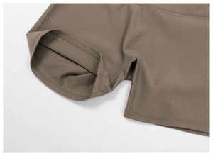 Detailed close-up of ribbed texture and stitching on brown high-waist yoga shorts