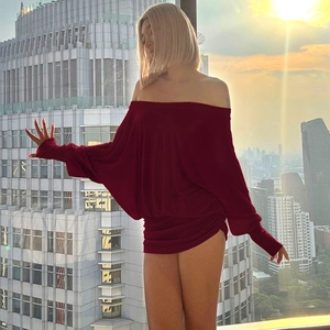 Détail d'une mini robe rouge foncé avec manches chauve-souris et épaules dénudées au coucher
