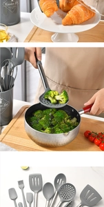 Macro view of grey silicone kitchen utensils with stainless steel handles in a holder