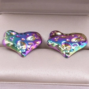 Macro shot of colorful iridescent 304 stainless steel heart earrings with textured surface