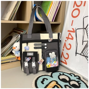 Detail of color-block canvas tote bag with functional buckle pocket and clear toy window