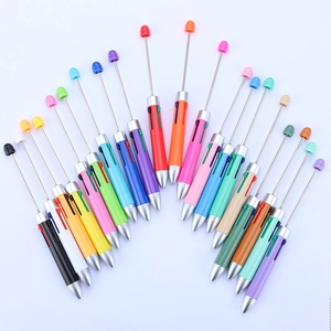 Macro shot of colorful DIY beaded ballpoint pens arranged in a fan shape on white background