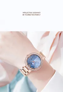 Detail of rose gold watch with sparkling rhinestones and a blue wave texture dial