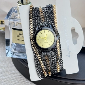 Detail view of a black and gold wrap-around quartz watch on a jewelry display card