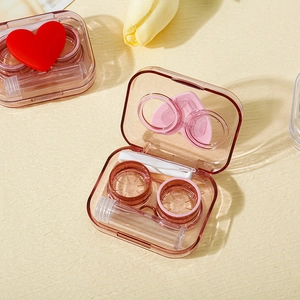 Detail view of coffee-colored transparent contact lens case set with tweezers and bottle
